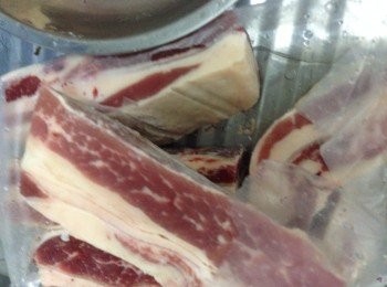 step2: 將急凍羊腩連包裝袋不要剪開連膠袋浸入水中解凍，攤軟羊腩後剪開袋倒走血水