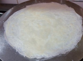 step5: 用另外一隻手將突出的白麵團壓開，細火煎至薄餅皮可以拿起，將另一面略煎即可