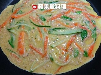 step2: 煎蛋：取出平底鍋，放入少許油，開中火，倒入蛋液慢煎。蛋液凝固時，灑上乳酪絲。乳酪融化後，用鍋鏟將蛋皮折起。