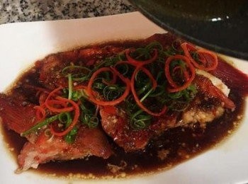 step9: 魚快蒸好前先燒熱ㄧ些香油； 接著將蒸好的魚從蒸籠取出，轉放在盤子上；並把泡在冷開水中的蔥絲和辣椒絲瀝乾後擺在魚身上，最後淋上香油即可。