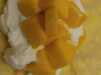 step8: 蛋皮鋪好後加cream和芒果粒卷好,可以再放入雪櫃再次雪凍或即食。