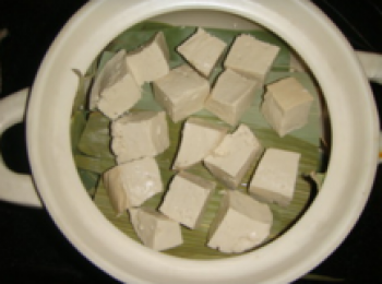 step3: 取一能密封的容器，墊上稻草（我木有找到稻草，就地取材用了端午節剩下的粽葉哈），將瀝幹水份的豆腐切成小方塊，均勻地碼在上面。