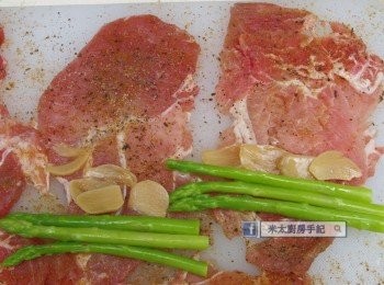 step2: 豬肉片上放<span class="group_2">調味料</span>，再放數條蘆筍和數片蒜片，捲成肉卷，收口處抹上一些生粉(太白粉)。