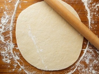 step6: 等麵糰發酵好以後，取一半的麵糰並桿成平體鍋的大小後用叉子稍微的來回戳幾下。