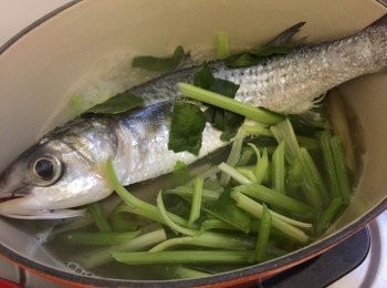 step6: 中火加入烏頭魚，若怕黏底，將少許芹菜鋪在魚底，鋪上檸檬葉，再加入芹菜放在一邊，關蓋煮5-6分鐘(視乎魚大細)，再熄火焗3分鐘即成