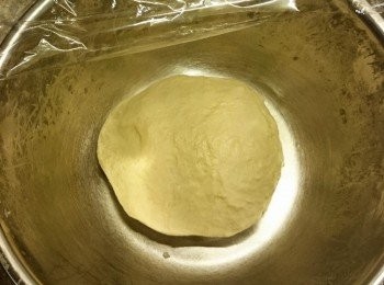 step5: 麵團搓完，加保鮮紙在麵放未開的焗爐，旁邊放一杯７０度熱水增加濕度溫度。發酵至兩倍大。（大小姐在這邊出了點小意外，晚飯吃晚了，發酵兩小時，整個麵團脹起了至保鮮紙高度，而且很黏。聞聞看沒有酸味就放膽進行餘下步驟。）