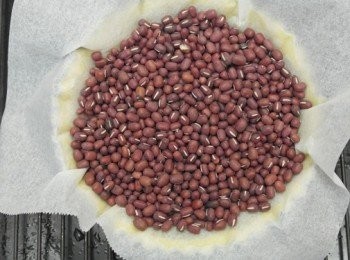 step9: 接著在派皮上鋪上烘焙紙倒入紅豆或是烘焙石，放入預熱180度烤箱烤約25分鐘。