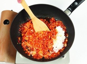 step8: 在關火的狀態下，倒入冷飯並與泡菜一起拌炒。