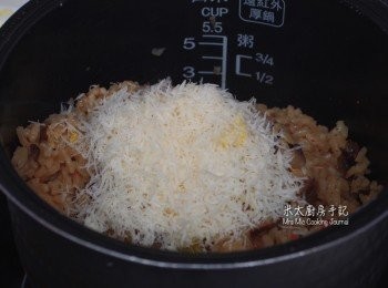 step7: 把所有炒過的材料放入電飯煲中，再加入餘下的龍蝦上湯至蓋過材料，按"Risotto"模式把飯煲熟；之後把芝士和1湯匙牛油放入熟飯內攪勻。