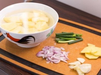 step3: 薯仔去皮洗淨切成一口大小浸於清水中備用。紅蔥頭去皮去頭切條，蒜頭去皮去頭切片，薑去皮切片 ，蔥切段