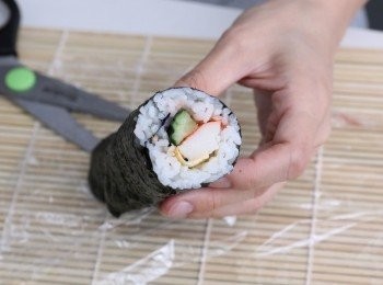 step3: 飯放8分就好，不要到頂；餸要放近自己身前方。抓住靠身體這一邊的竹簾往外捲，一邊捲一邊壓實。