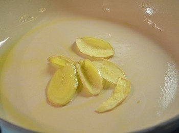 step1: 1. 白米洗淨，瀝乾水分。如用糯米需先浸泡4小時或以上。雞塊洗淨切塊，瀝乾水分備用。

2. 鍋中加入麻油和薑片以小火慢慢煸至薑片邊緣呈微焦黃。（用小火慢慢煸炒，能使薑汁溶解在麻油當中，可增強身體的抗寒能力，從而達到溫補的功效。）