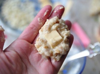 step3: 取出適量的粉餬在手上，再加入1小片的起司片當內餡包覆起來