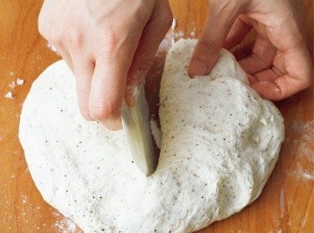 step7: 用刮板在麵團上切出一道切口，深度為，將切口往左右拉開並搓揉成棒狀。