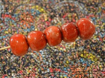 step8: 再把山楂串取出放在盤上，等待冷卻表面糖漿凝固，冰糖葫蘆就做好了。