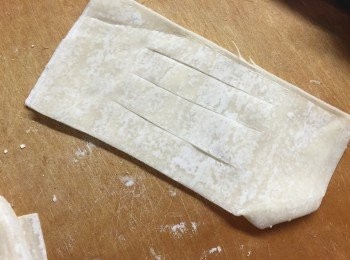 step2: 取2塊長方皮疊在一起，中間直切三刀但保持末端相連。