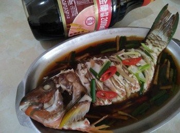 step3: 經過10分鐘後，把蒜頭放入鍋中，快接近15分鐘後，用筷子插入清蒸鰱魚【澎湖野生水產】身最厚的地方，筷子若能輕鬆穿過，表示熟透了，如果還沒就多蒸2分鐘後，再試一次。