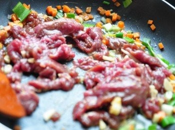 step3: 以2大匙油熱鍋，將紅蘿蔔丁、蔥花、芹菜末下鍋爆香，再放入醃漬過的牛肉片略拌炒，再將豆芽菜放入悶煮拌炒