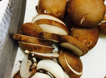 step2: 廚房紙沾少許水，抹去蘑菇上的泥污。去椗，切厚片。