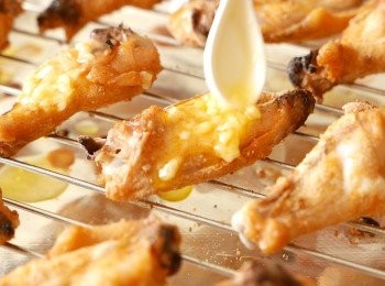 step7: 平均地在<a href="https://bit.ly/3zHU5V3" target="_blank" data-keyword="雞翼" class="guide-link"><strong>雞翼</strong></a> <span style="display:inline-block;vertical-align:middle;margin-top:-3px;color:initial;border-radius:3px;padding:2px 3px;font-size:12px;line-height:14px;background:#87d300;color:#fff;">即買</span> 上抹上一半份量的蒜蓉牛油。