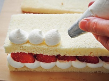 step7: 再疊上1片海綿蛋糕，擠上發泡鮮奶油之後，以草莓裝飾。再重複做1次。