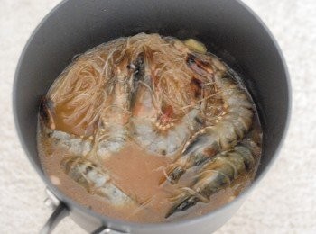 step5: 下鮮蝦，粉絲和醬汁，蓋上煲蓋，用中火煮沸，然後轉小火煮四分鐘即成！