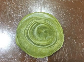 step13: 接著從第一個切疊的麵皮開始桿圓,先用趕麵棍從中間壓下,換一個方向再壓一次後開始從週邊將麵皮滾薄,桿成中間略厚周圍薄的麵皮.