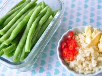 step1: 備料:將略川燙好的四季豆切成對等的長度剛剛好放在樂扣樂扣長形保鮮盒，蒜頭切細末、辣椒切小段、一小塊無鹽奶油備用