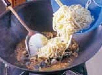 step2: 加入調味料後，放入油麵與麵拌炒在一起。