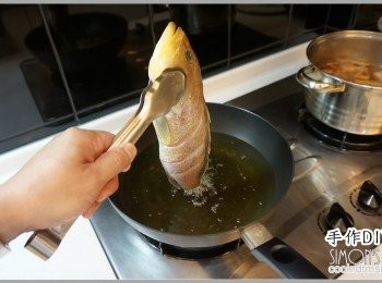 step2: 鍋內放足量油，大火燒熱之後將魚用夾子夾住緩緩放入。
記得不要一次就把魚放進去炸，而是將魚皮表面都先炸
乾。