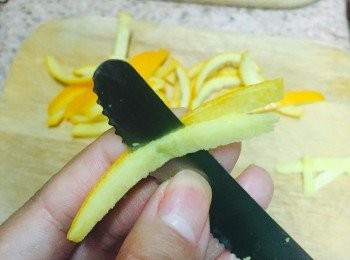 step4: 趁熱將橙皮平放砧板上，用刀小心將皮內白色部分切走。