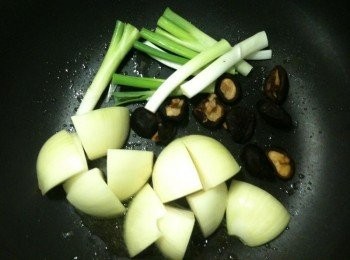 step5: 將步驟1的洋葱、擠出水份的乾香菇（香菇水要留著備用）、葱白放入平底鍋，利用步驟4所煉好的雞油炒香（仍維持在中火）。