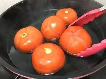 step3: 燒熱滾水, 將蕃茄加入, 期間用夾將蕃茄反轉, 至蕃茄皮自然脫落