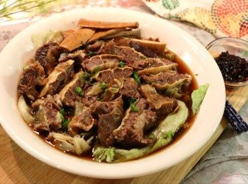 step8: 將煮好的生菜鋪在盤中，然後放上切好的牛腩塊，淋上適量滷水湯汁後即可直接享用。