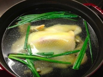 step1: 將冰鮮雞放在室溫，解凍洗淨後，用粗鹽擦雞身，沖洗乾淨後抺乾雞身。鑊加水（水蓋過成隻雞），煮滾後放入蔥同薑片，再水滾加上鑊蓋，熄火浸雞30分鐘。立即將隻雞放入冰水浸，灘凍及晾乾水份。