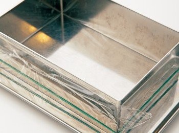 step18: 在烤模底部包上保鮮膜，用橡皮筋加以固定，做成底部，翻回正面放在鐵盤上。