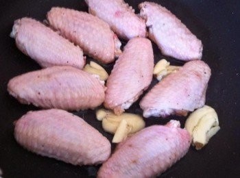 step2: 取出平底鍋加入1匙食油，把醃製好的雞中翅下鍋，中火前後煎至微焦。