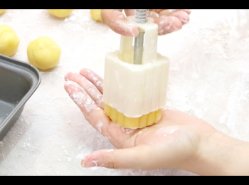 step9: 於月餅模中撒入少量麵少，放入月餅麵糰，輕輕壓成月餅形。