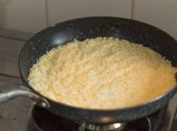 step5: 平底鑊開中慢火，鑊熱加入1-2湯匙油，油熱後放入已拌好之米飯，盡量鋪平及壓扁，鋪好靜煎約5-6分鐘至成底部微焦及凝固