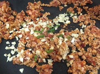 step3: 熱鍋後下豆瓣醬，先炒一分鐘至香味散發，再加入豬絞肉，炒至肉變色後，下蒜末及薑末炒均勻。