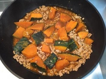 step3: 接著放入南瓜和蒸南瓜出的水，再加一些水約蓋過南瓜和絞肉，拌勻後蓋上鍋蓋小火悶15分鐘，直到南瓜熟透變軟並收汁