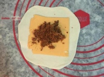 step11: 取第一個捲好的麵糰桿成中間後旁邊薄的圓型，放上起司片和肉鬆，像包包子ㄧ樣的包起來。