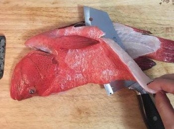 step2: 延著魚骨，切下一片魚菲利，再剁下魚下巴備用。（買魚時也可請有提供殺魚的魚販幫忙卸菲利魚排）