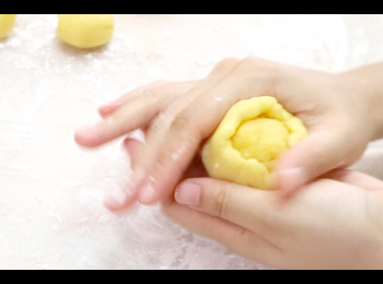 step8: 以刮板將<span class="group_2">酥皮</span>麵糰壓成圓片狀，包入<span class="group_1">奶黃餡</span>，以手指虎口位慢慢堆至封口。