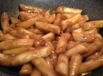 step3: 將年糕、韓國辣椒醬、放入鍋中。片糖放
在中間。 (喜歡吃辣一點的，可加1大匙的辣椒粉)
煮滾後，轉用中小火，邊煮邊翻炒(翻炒是要
防粘鍋底) ，直到年糕變軟。