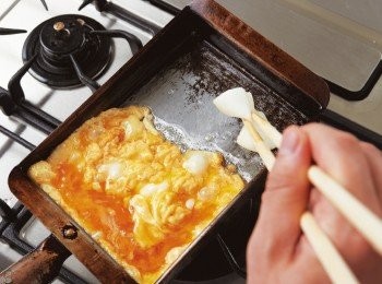 step4: 待蛋汁呈半熟狀，快速將煎鍋前半部的煎蛋拌入後半部，並於鍋中空出的位置塗油。