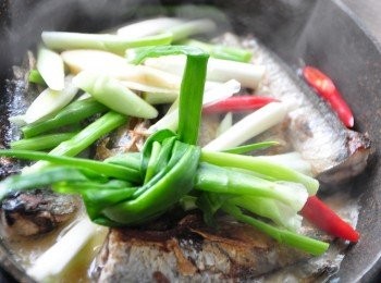 step3: 接著放入蔥把、大蒜片、辣椒，並倒入米酒滾煮