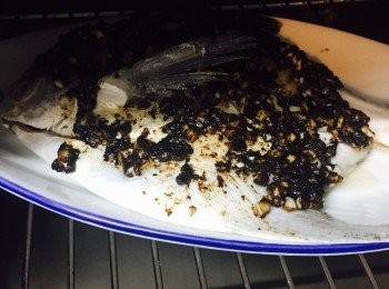 step3: 碟上先放兩片薑，然後放上鯧魚。鯧魚上再放兩片薑，然後均勻塗上蒜蓉豆豉醬。隔水蒸7分鐘或用蒸爐110度蒸10分鐘至熟。