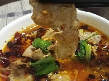 step3: 再煮滾湯，轉小火逐件牛柳片攤開放入煮約30秒左右加入生粉水兜勻，牛柳片煮至僅熟撈起放入大碗並淋上熱湯(湯不用蓋過面) ，灑上剩餘蒜蓉及辣/花椒碎於頂。最後燒熱一湯匙辣椒油，一湯匙花椒油及一湯匙油燒至冒煙，淋上蒜蓉及辣/花椒碎，加上芹菜花或芫茜裝飾完成