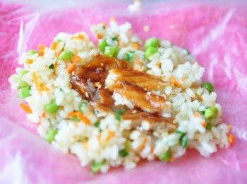 step5: 利用乾淨得棉布套上塑膠袋包覆，鋪上一層炒香的有機米飯，放上適量的蒲燒鯛魚塊在中間